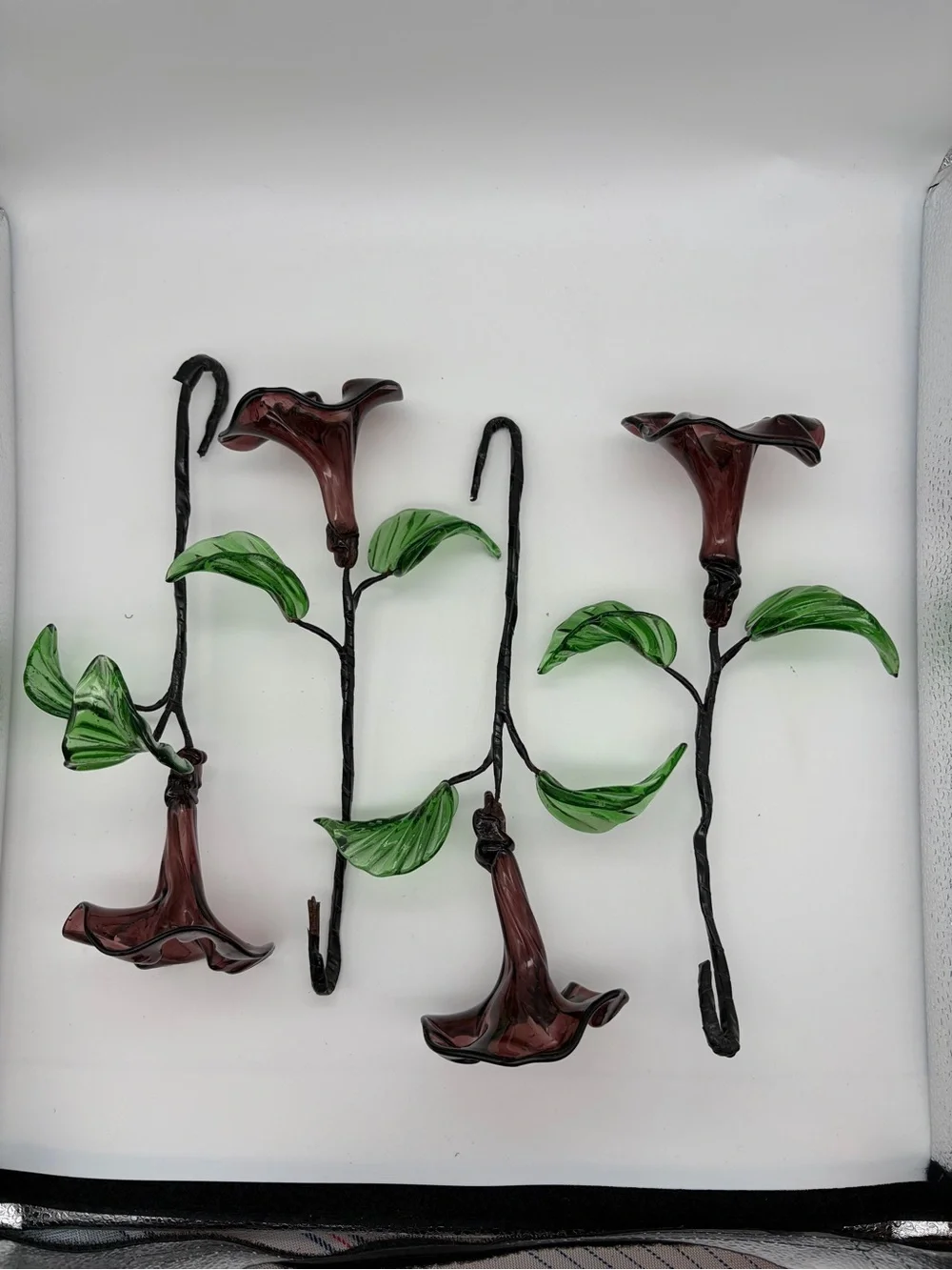 Vintage green swing glass vase with purple lily trumpet flowers.